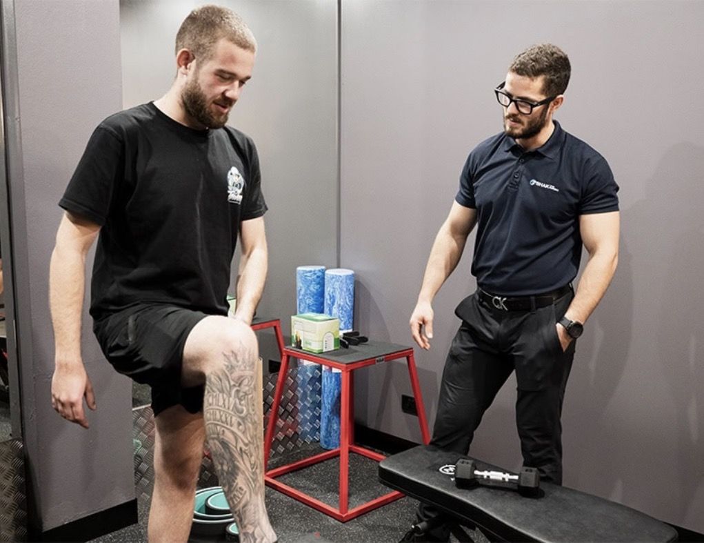 Samir assessing a client's knee during a rehabilitation session